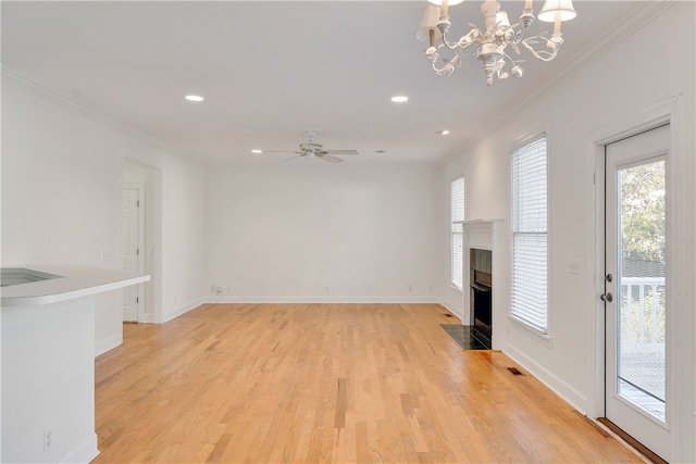 unfurnished living room featuring crown molding, light hardwood / wood-style flooring, and ceiling fan with notable chandelier