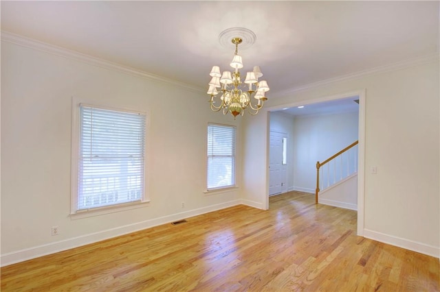 unfurnished room with plenty of natural light, ornamental molding, a notable chandelier, and light hardwood / wood-style flooring