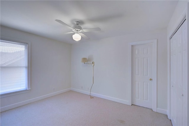 spare room featuring light carpet and ceiling fan