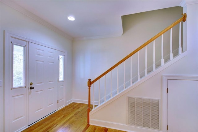 foyer with light hardwood / wood-style flooring and ornamental molding