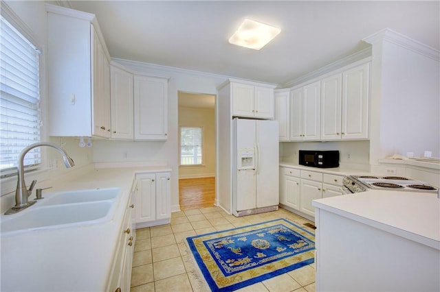 kitchen featuring white cabinets, light tile patterned floors, white appliances, and sink