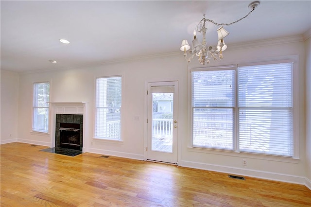 112 Newfield St, Saint Simons Island, GA 31522 - unfurnished living room with wood finished floors, a chandelier, ornamental molding, a tiled fireplace, and recessed lighting