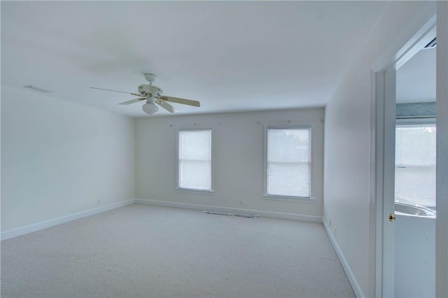 spare room featuring light carpet and ceiling fan