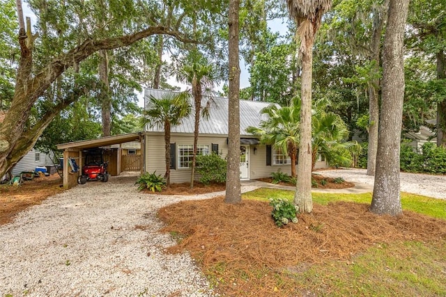 205 Palmetto St, Saint Simons Island, GA 31522 - view of front of house with driveway, a carport, and a metal roof