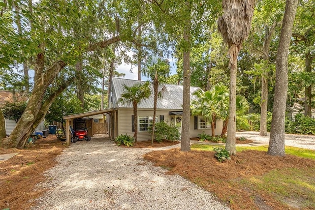 205 Palmetto St, Saint Simons Island, GA 31522 - view of front of home with gravel driveway, a carport, and a metal roof
