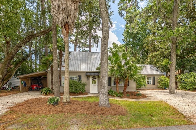 205 Palmetto St, Saint Simons Island, GA 31522 - view of front of home featuring driveway, a metal roof, and an attached carport
