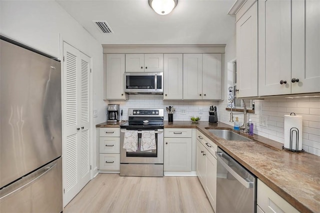 205 Palmetto St, Saint Simons Island, GA 31522 - kitchen featuring stainless steel appliances, tasteful backsplash, and light wood-style floors