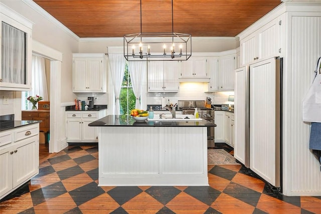 kitchen featuring stainless steel gas range oven, dark countertops, wood ceiling, and ornamental molding