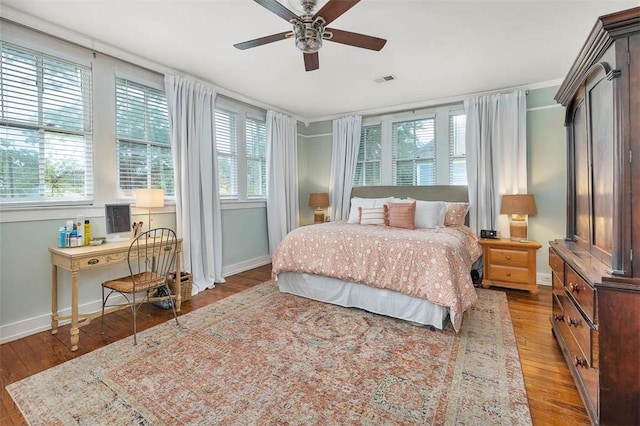 bedroom featuring baseboards, multiple windows, and hardwood / wood-style floors