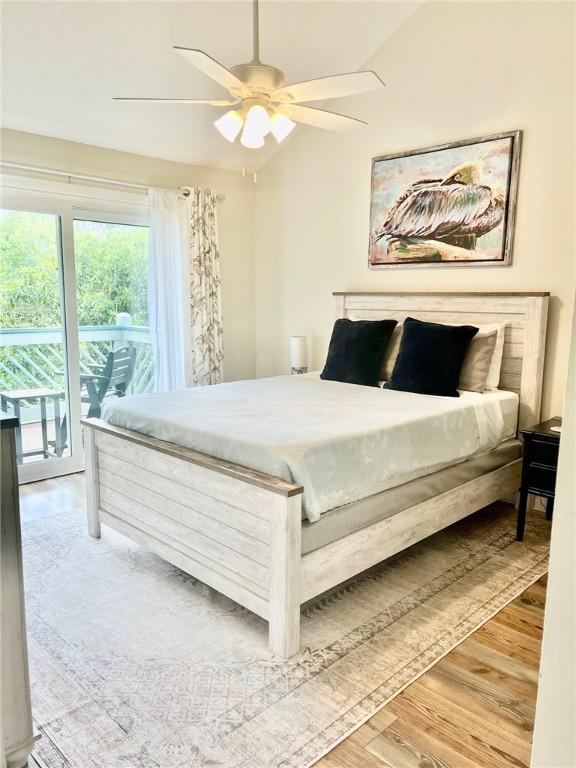 bedroom featuring access to exterior, ceiling fan, lofted ceiling, and hardwood / wood-style flooring