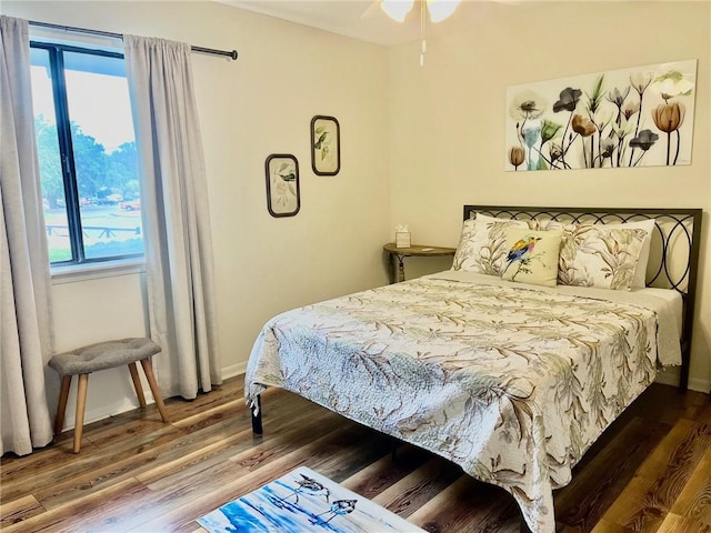 bedroom with wood-type flooring, multiple windows, and ceiling fan