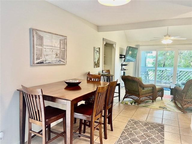 dining area featuring ceiling fan, light tile patterned flooring, and lofted ceiling with beams