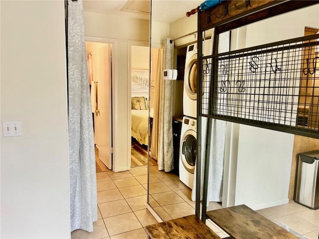 laundry area featuring light tile patterned floors and stacked washer / drying machine