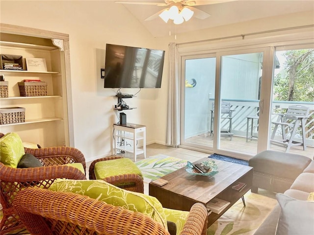 living room with ceiling fan, light tile patterned floors, and vaulted ceiling