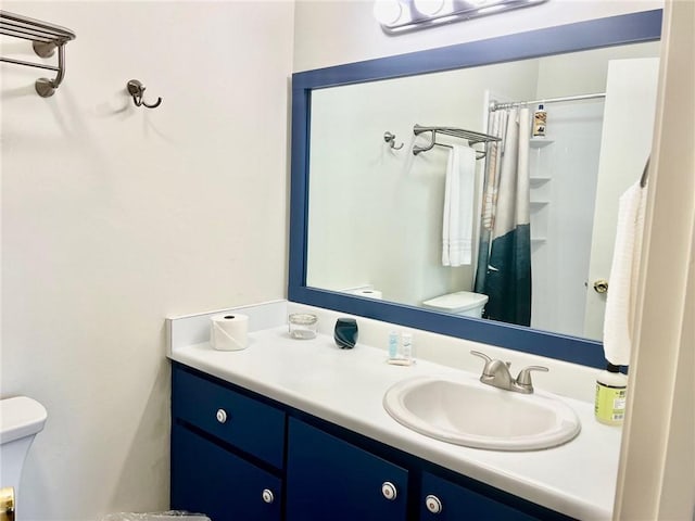 bathroom featuring curtained shower, vanity, and toilet