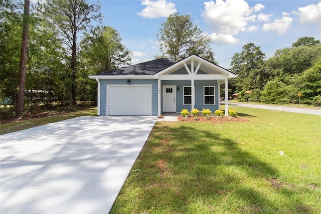 view of front of house featuring covered porch, a garage, and a front yard