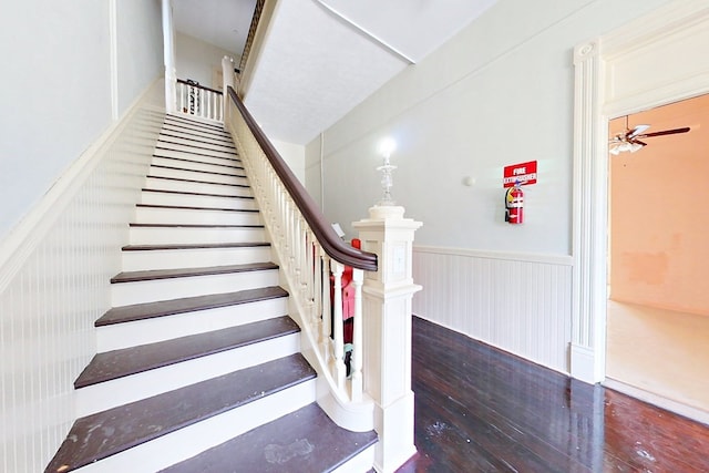 415 Dewey St, Waycross, GA 31501 - stairway with wood finished floors, a wainscoted wall, and a ceiling fan