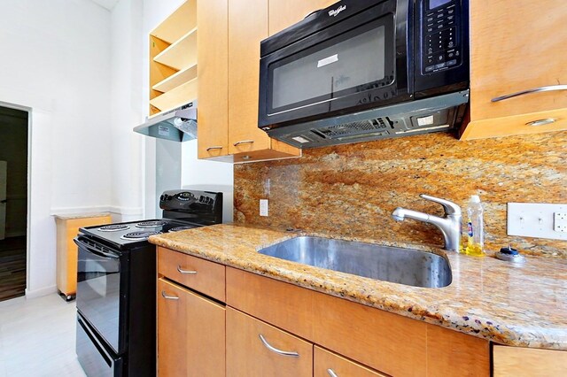 415 Dewey St, Waycross, GA 31501 - kitchen with black appliances, light stone countertops, backsplash, and under cabinet range hood