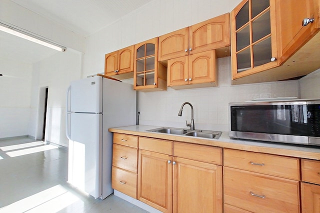 415 Dewey St, Waycross, GA 31501 - kitchen featuring stainless steel microwave, freestanding refrigerator, light countertops, backsplash, and glass insert cabinets