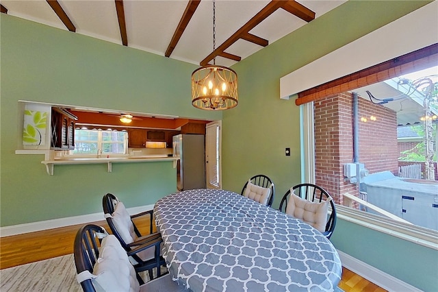 dining area with light wood finished floors, a chandelier, and baseboards
