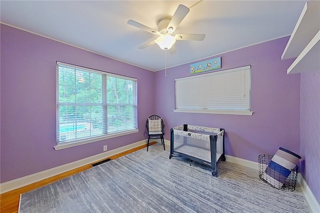 sitting room featuring a ceiling fan, baseboards, and wood finished floors