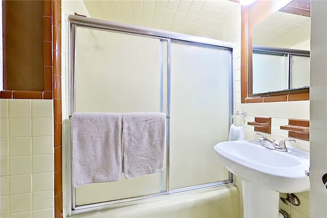 bathroom featuring bath / shower combo with glass door