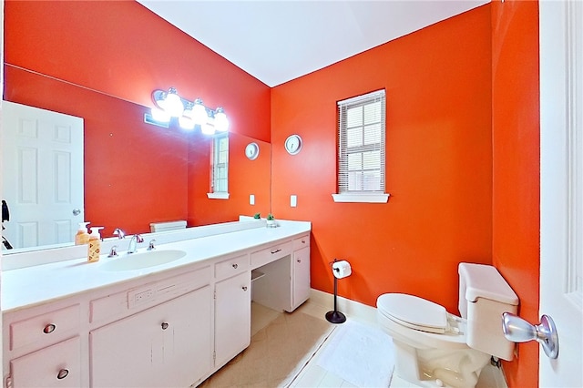bathroom with toilet, vanity, tile patterned floors, and baseboards