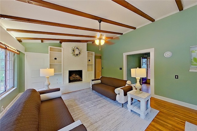 living room featuring baseboards, a fireplace, wood finished floors, and ceiling fan