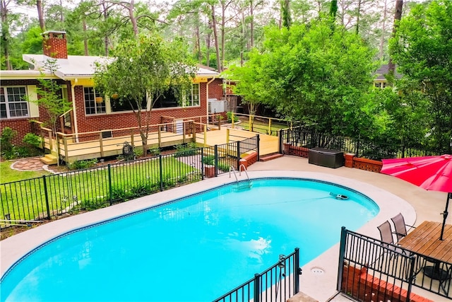 view of swimming pool with view of wooded area