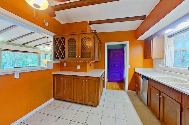 kitchen with a ceiling fan, stainless steel dishwasher, brown cabinetry, and light countertops