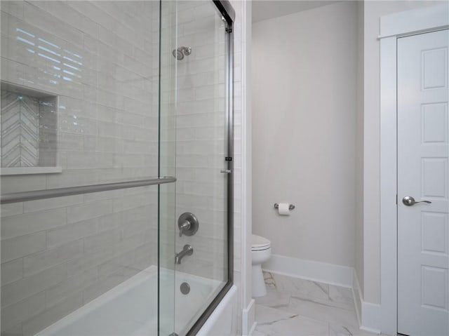 bathroom featuring toilet and shower / bath combination with glass door