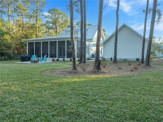 rear view of property with a patio area, a sunroom, and a yard