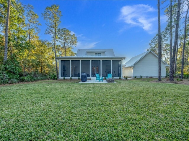 rear view of property featuring a lawn, a patio area, and a sunroom