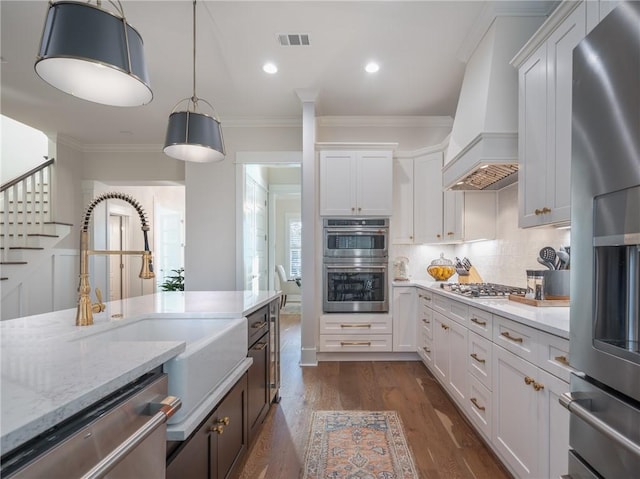 kitchen featuring premium range hood, white cabinetry, and appliances with stainless steel finishes