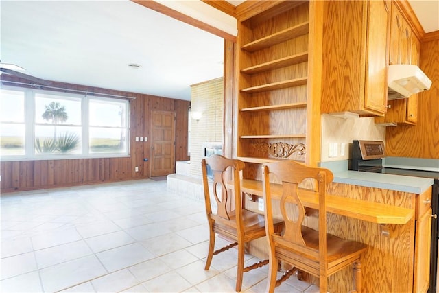 dining area featuring wood walls and light tile patterned flooring