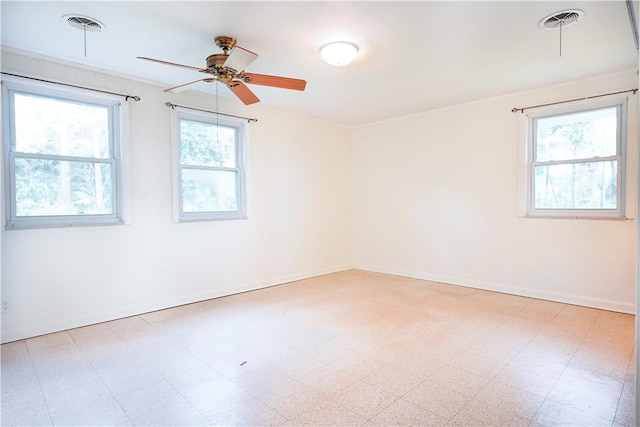 empty room with ceiling fan and plenty of natural light