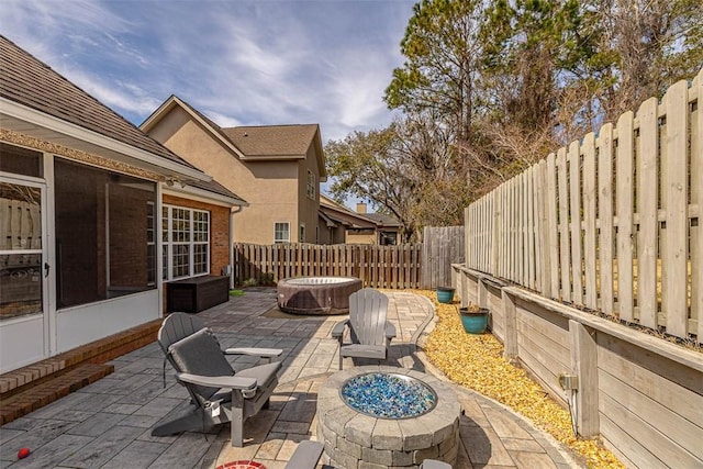 257 Villager Dr, Saint Simons Island, GA 31522 - fenced backyard with a fire pit, a patio, a sunroom, and a jacuzzi