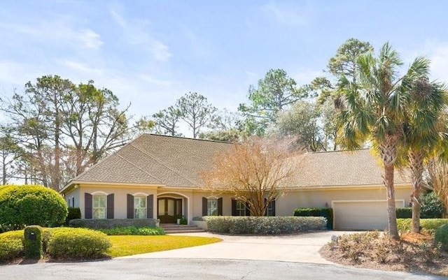 view of front facade featuring driveway, an attached garage, and stucco siding