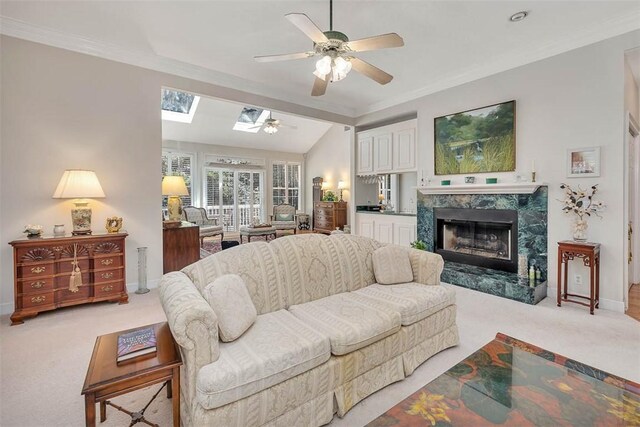 1064 Sea Palms W Dr, Saint Simons Island, GA 31522 - carpeted living room featuring a ceiling fan, a skylight, a fireplace, and crown molding