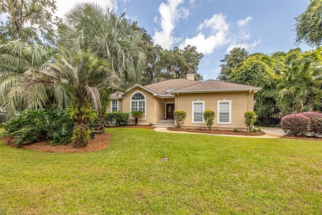 1064 Sea Palms W Dr, Saint Simons Island, GA 31522 - ranch-style home featuring stucco siding, a front yard, and a chimney