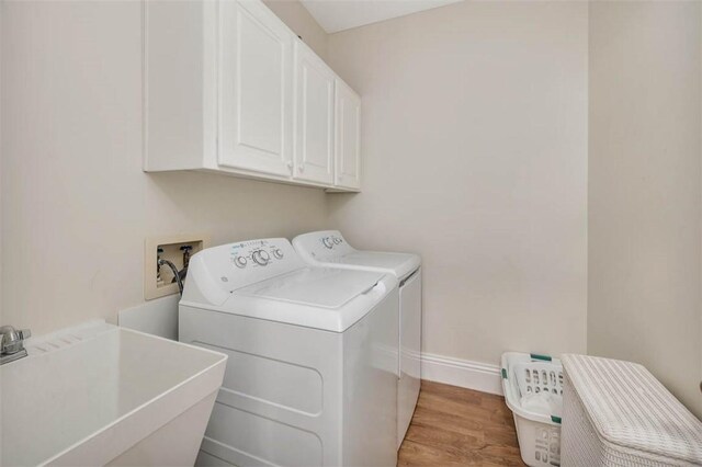 1064 Sea Palms W Dr, Saint Simons Island, GA 31522 - washroom with separate washer and dryer, cabinet space, and light wood finished floors