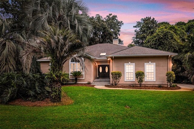 1064 Sea Palms W Dr, Saint Simons Island, GA 31522 - view of front of home featuring a yard, a chimney, and stucco siding