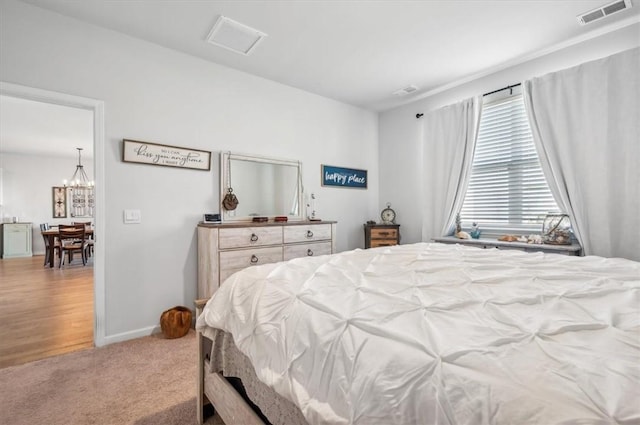 bedroom featuring carpet flooring and a chandelier