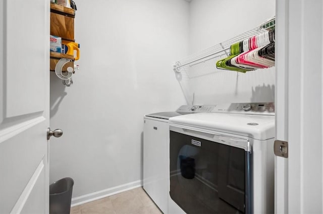 clothes washing area featuring light tile patterned flooring and washing machine and clothes dryer