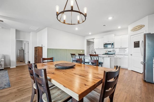 dining room featuring a notable chandelier and light hardwood / wood-style floors