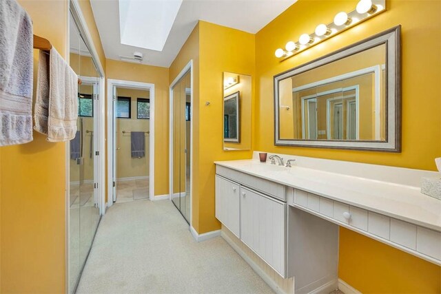 899 Wimbledon Dr, Saint Simons Island, GA 31522 - bathroom featuring vanity, a skylight, and baseboards
