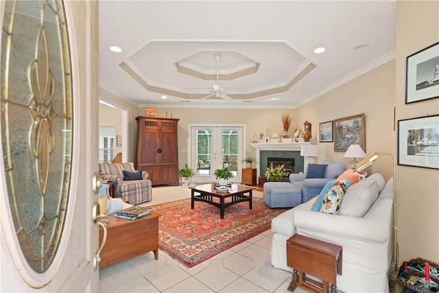 117 Serenoa Dr, Brunswick, GA 31523 - living area with ornamental molding, light tile patterned floors, a lit fireplace, ceiling fan, and a tray ceiling
