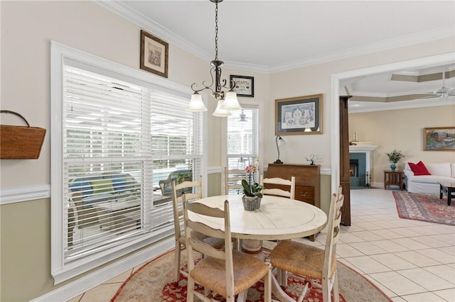 117 Serenoa Dr, Brunswick, GA 31523 - dining area featuring ornamental molding, light tile patterned flooring, a fireplace, a chandelier, and ceiling fan