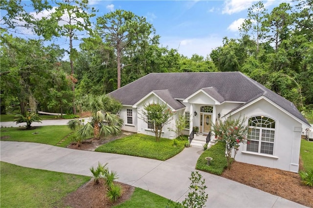 117 Serenoa Dr, Brunswick, GA 31523 - single story home featuring a front yard, a shingled roof, and stucco siding