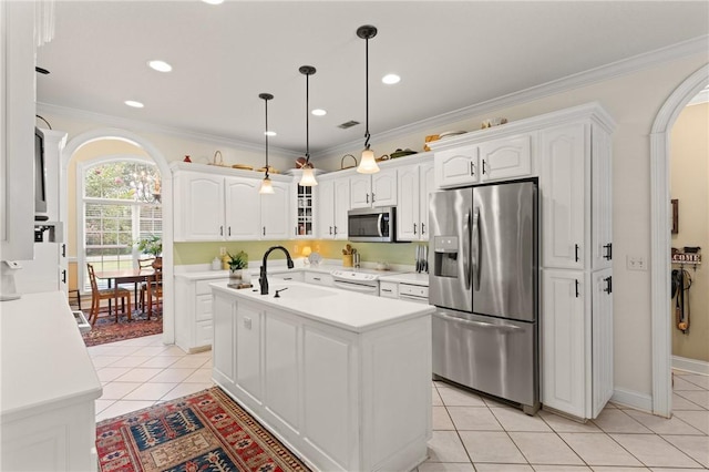 117 Serenoa Dr, Brunswick, GA 31523 - kitchen featuring appliances with stainless steel finishes, arched walkways, light tile patterned flooring, light countertops, and white cabinetry